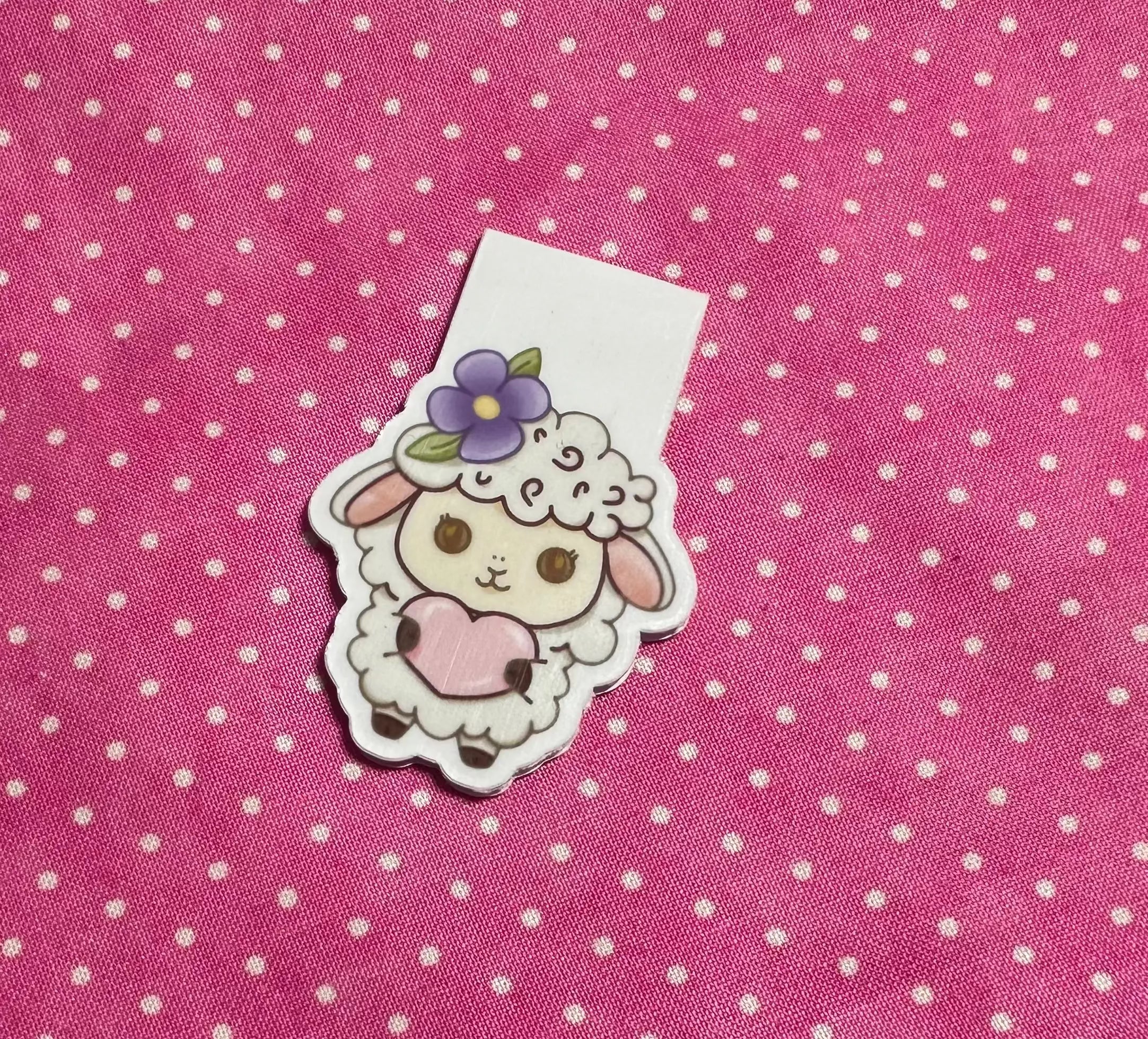 Sticker of a cute animal with a flower on a pink polka dot background