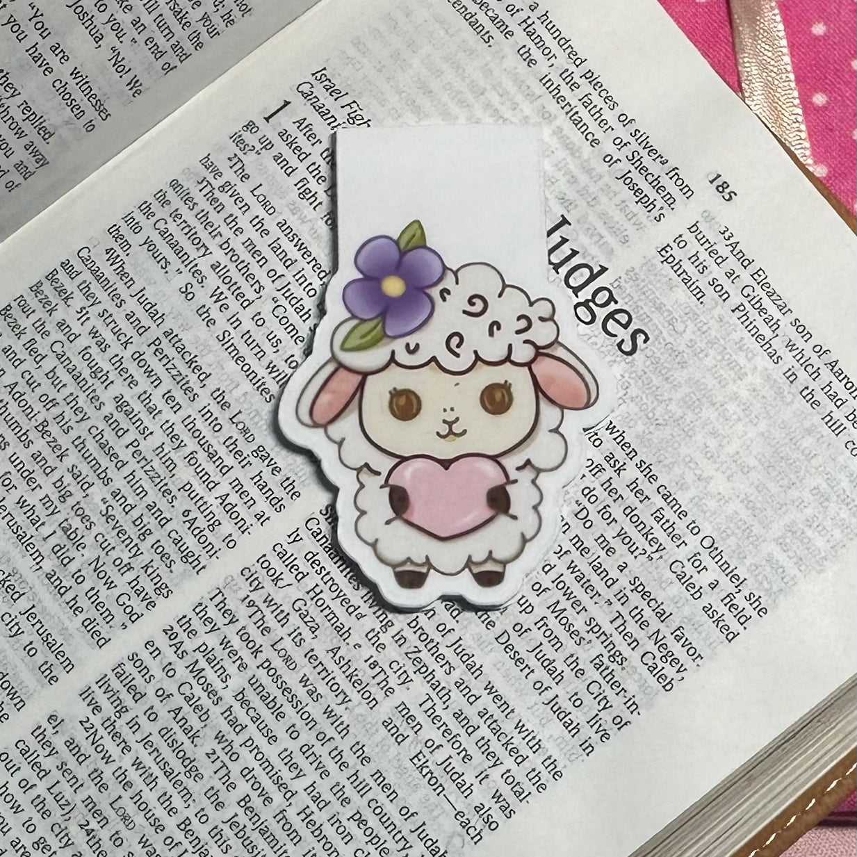Cute cartoon sheep bookmark with a flower on an open book