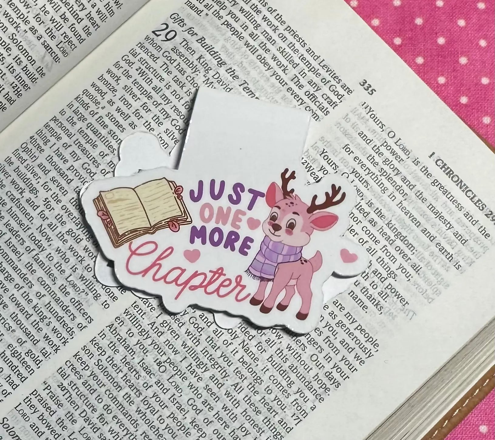 Bookmark with a cartoon deer and text 'Just One More Chapter' on an open book.