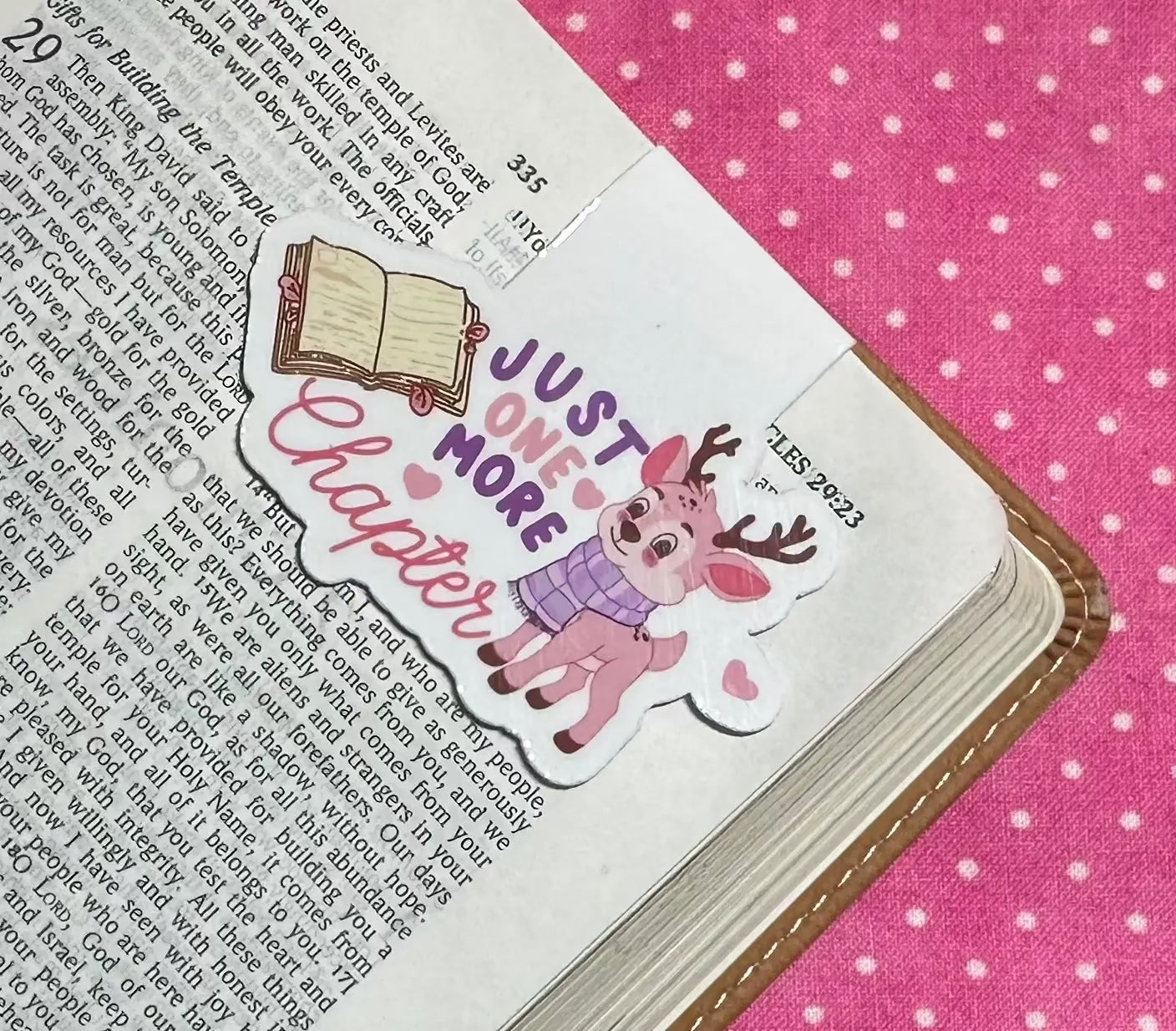 Book with a decorative bookmark featuring a deer and text on a pink polka dot background