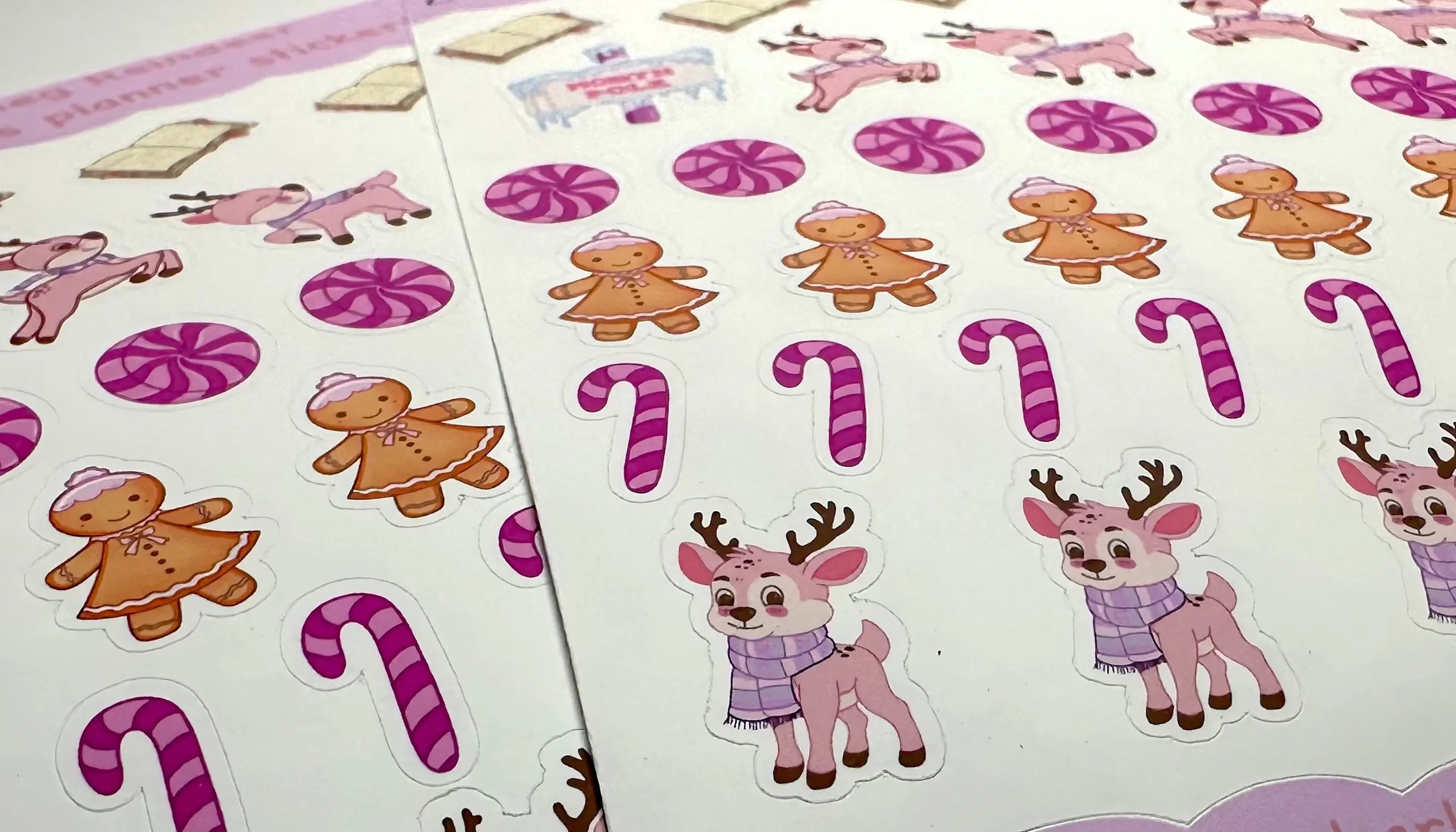 Sheet of Christmas-themed stickers featuring reindeer, gingerbread men, and candy canes on a white background.
