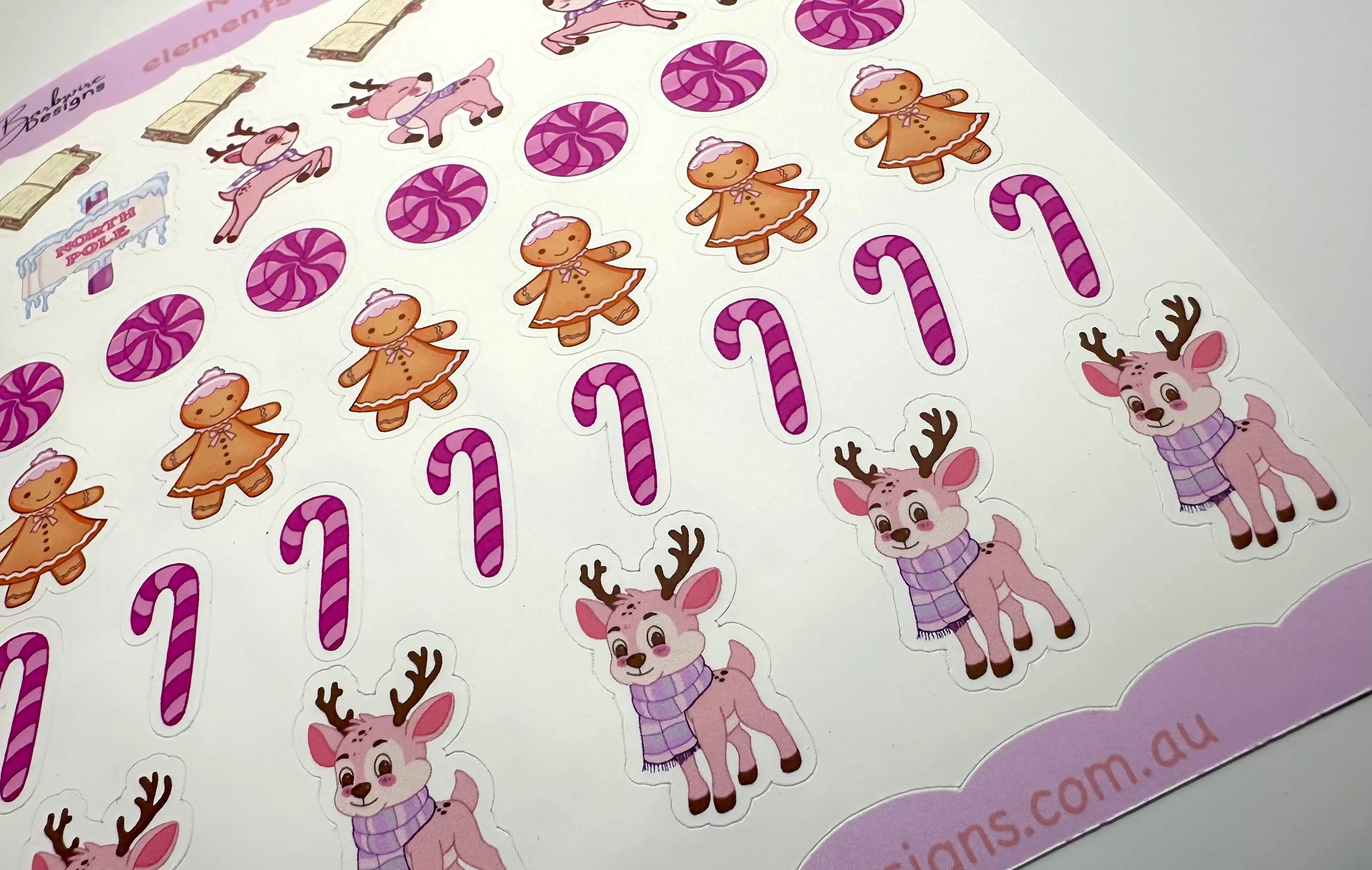 Sheet of Christmas-themed stickers featuring reindeer, candy canes, and gingerbread men on a white background.