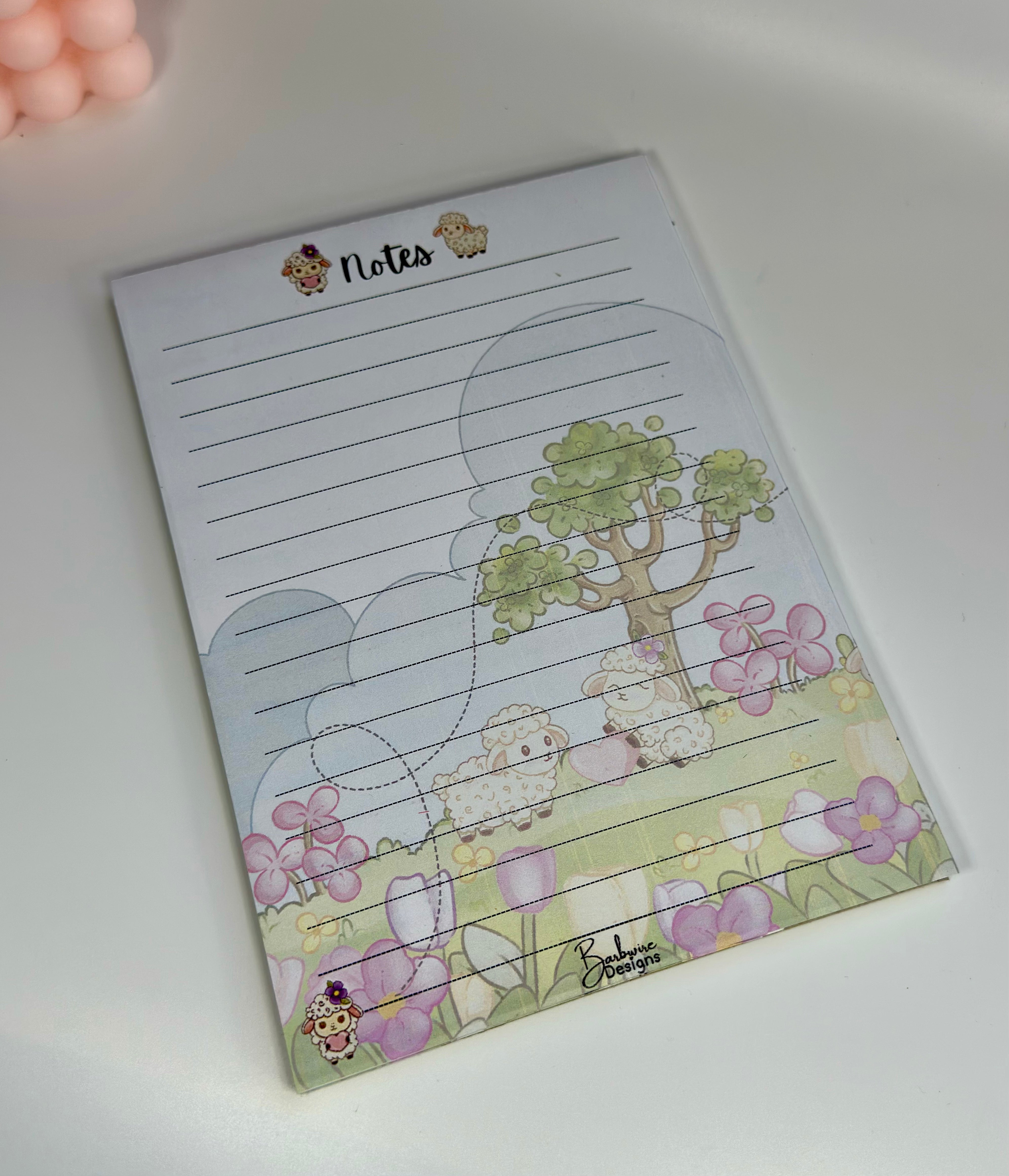 Notebook with cartoon sheep and flowers on a white background